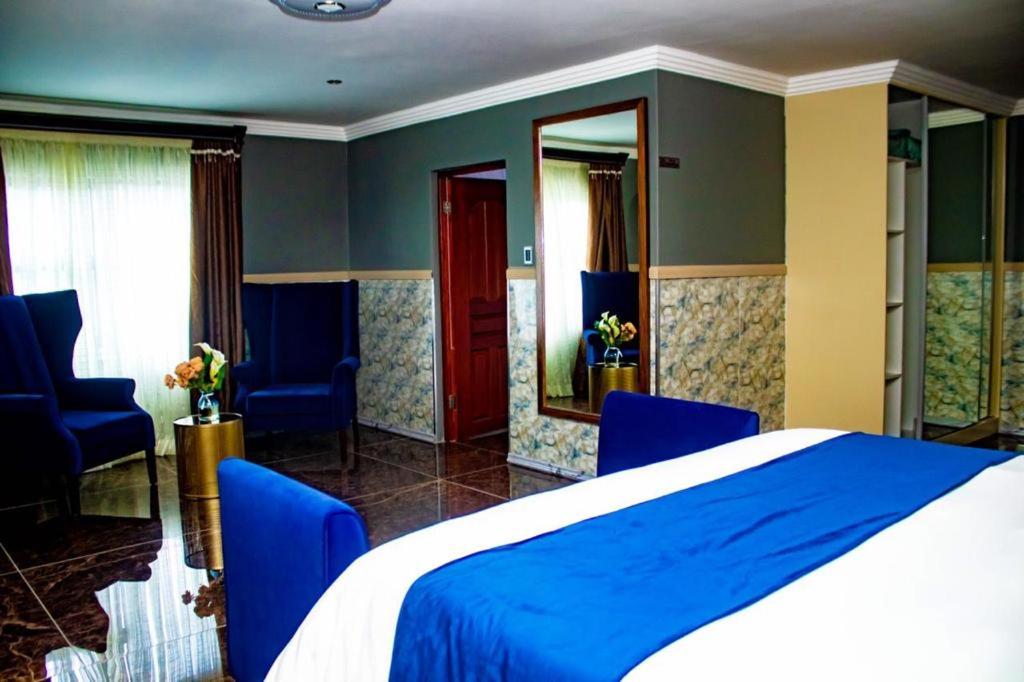 GiyaniXilumani Hotel的一间卧室配有蓝色的床和蓝色的椅子