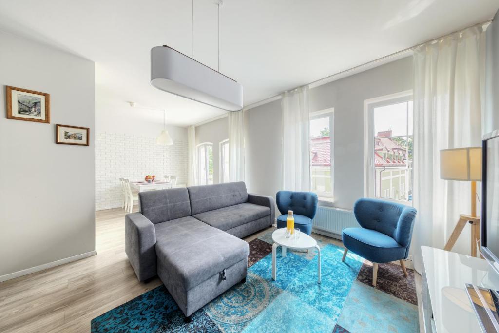 吉日茨科Shum Jeziora Apartament nr 7的客厅配有沙发和2把蓝色椅子