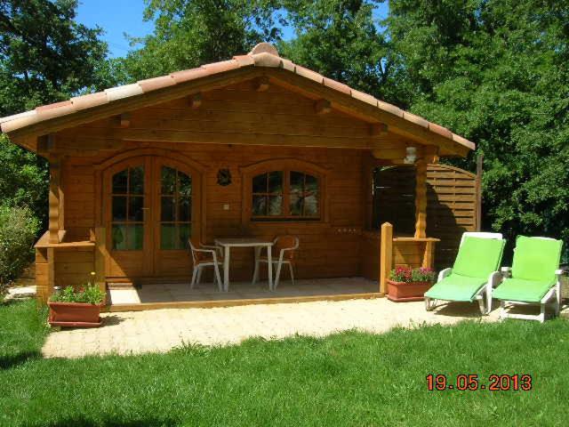 布克贝莱尔Chalet l'emiline , Gite climatisé au sud d'aix avec piscine的小屋设有桌椅