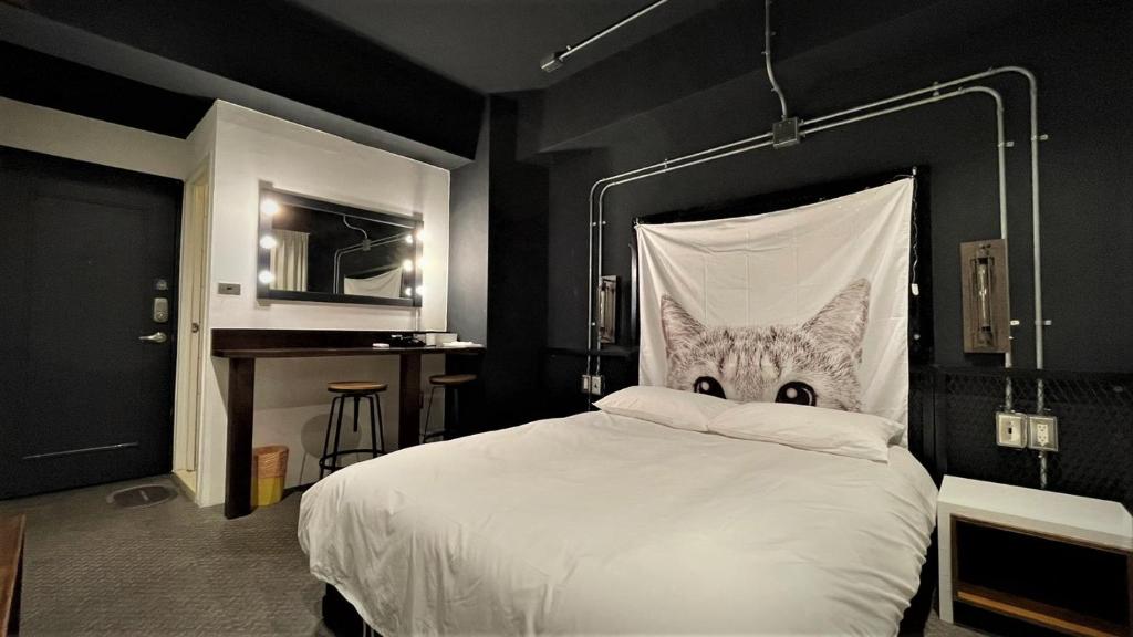 台中市逢甲旅树的卧室配有白色床,面朝猫