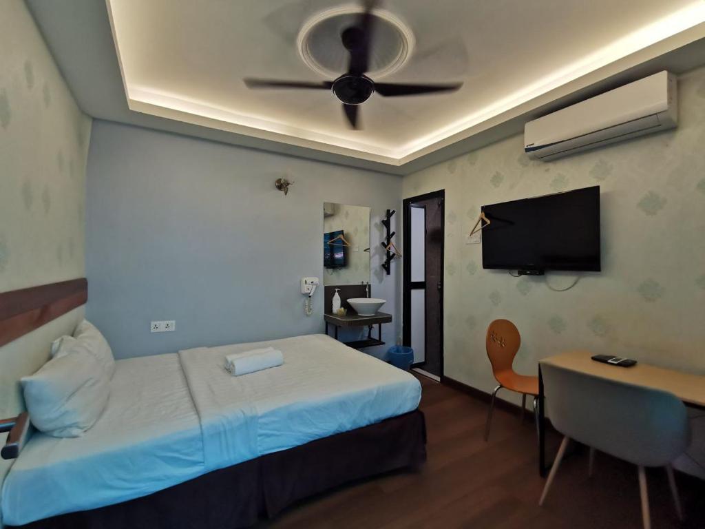 吉隆坡Cheras-Miharja Homestay @Sunway Velocity的一间卧室配有一张带吊扇的床和一张书桌。