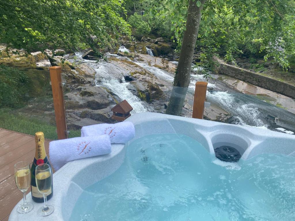 贝塞斯达V13 - The Falls with Hot Tub的瀑布前的热水浴池,备有两杯葡萄酒
