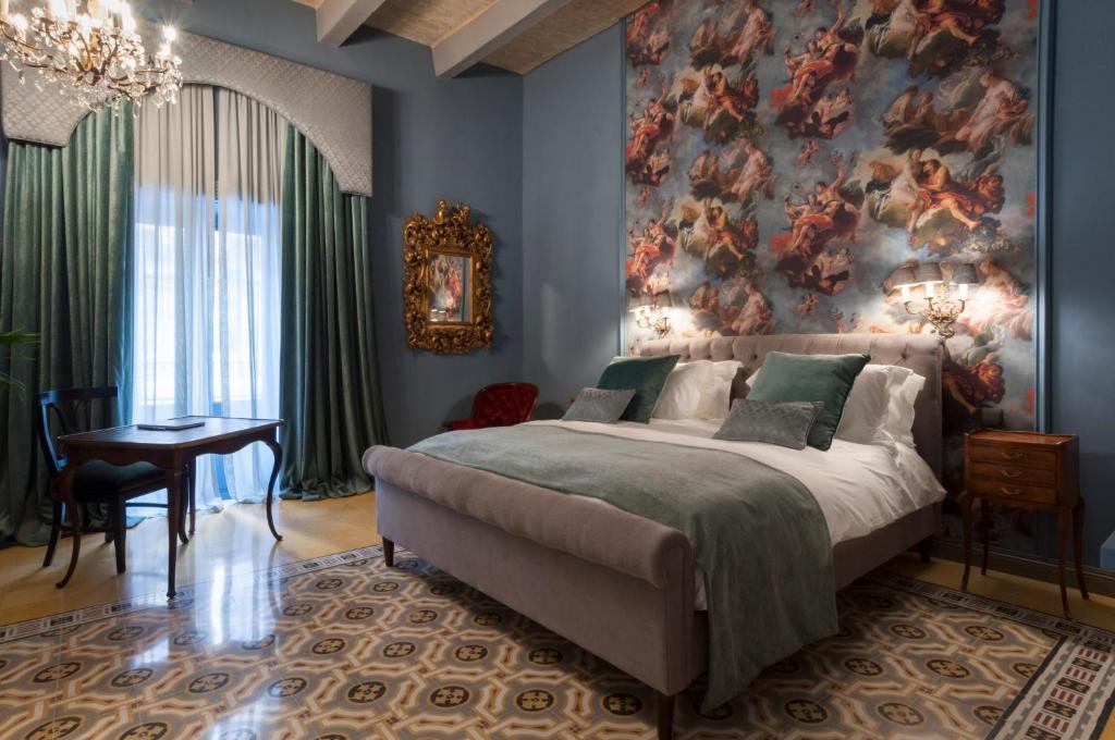 瓦莱塔The Coleridge Boutique Hotel In Valletta的卧室配有一张大床,墙上挂有绘画作品