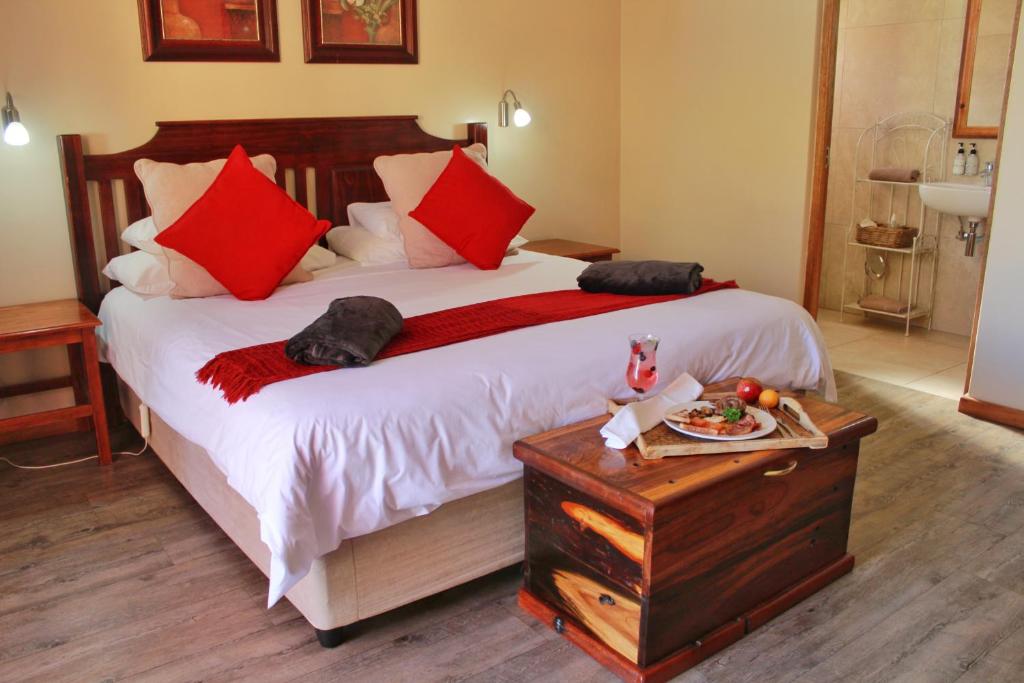博福特西17 on Bird Guest House的一间卧室配有一张带红色枕头的大床
