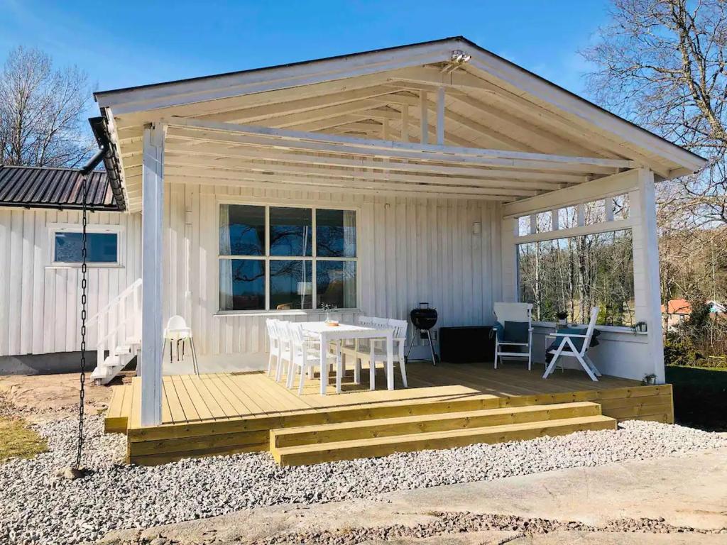 弗加尔巴卡Panoramablick - Meer - Familien - Remote Work的白色的小房子,配有桌子和椅子