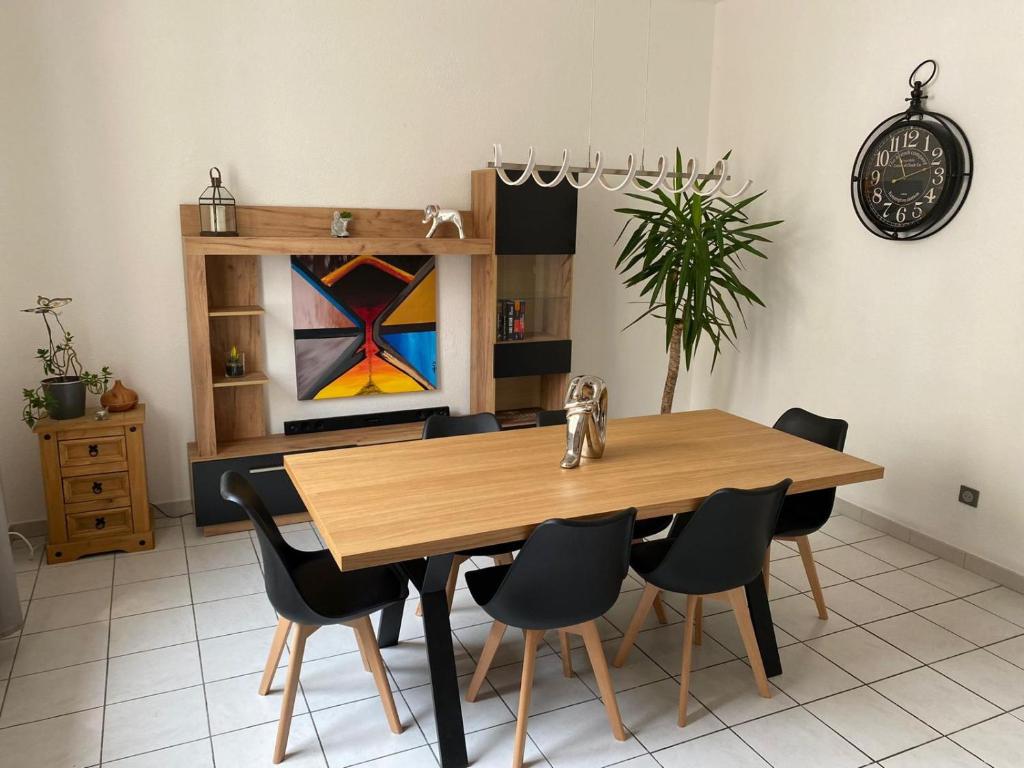 奥朗日APPARTEMENT SPACIEUX的一间带木桌和椅子的用餐室