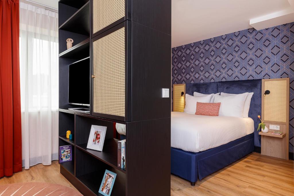 阿姆斯特丹Boutique Apartments Amsterdam的一间卧室设有一张床和一个书架