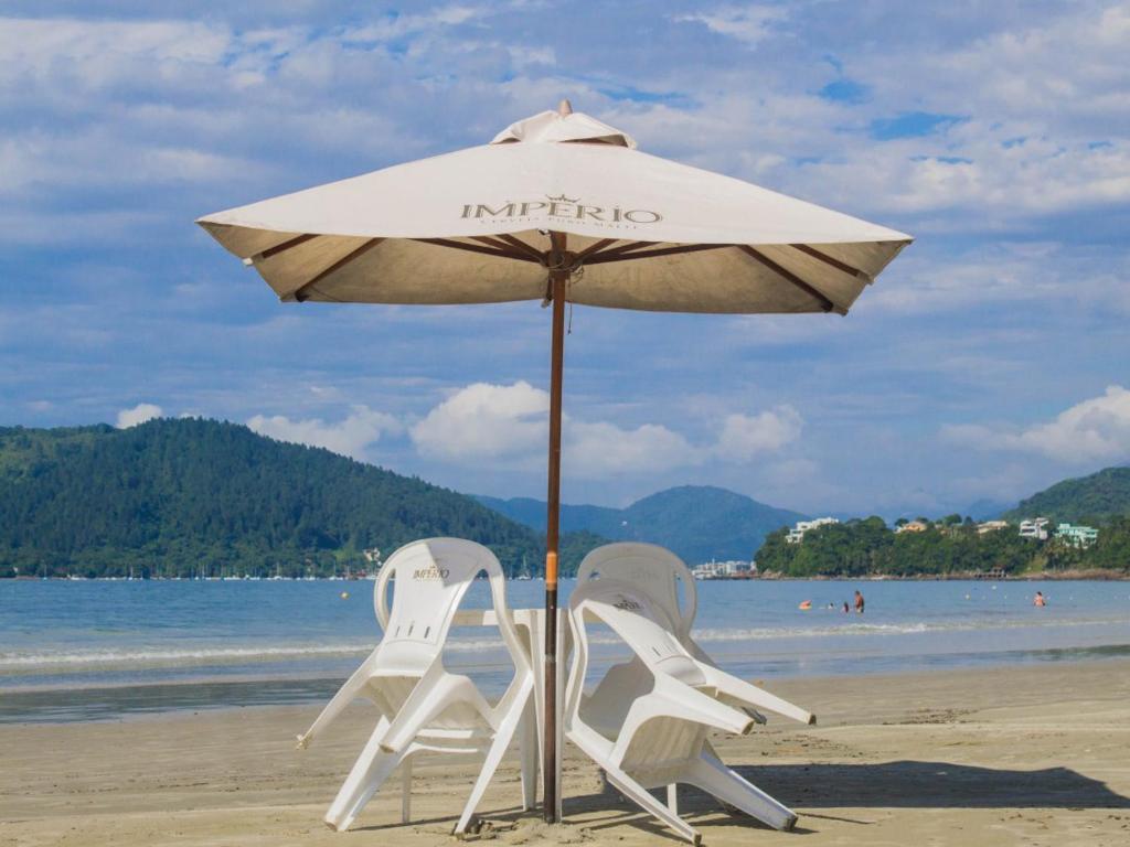 乌巴图巴Pousada Maanaim的海滩上的两把椅子和一把遮阳伞