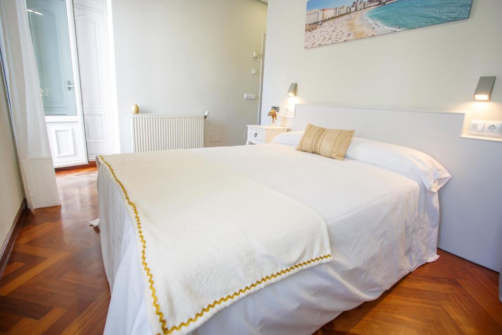 拉科鲁尼亚Hostal Costa Coruña的卧室配有一张白色大床和黄色缝 ⁇ 