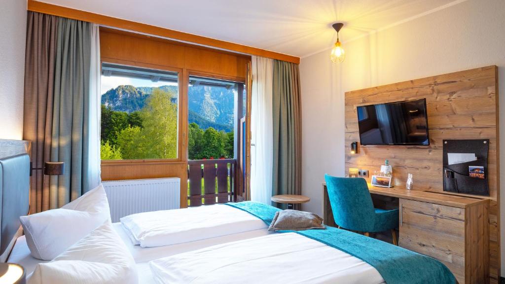 因泽尔Das Wiesgauer - Alpenhotel Inzell的酒店客房设有两张床和窗户。