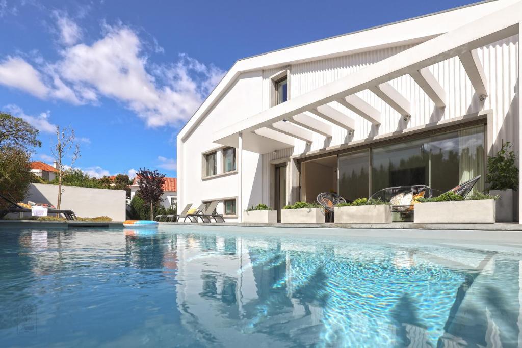 里斯本Santa Joana Apartments with garden and heated pool的大楼前带游泳池的房子