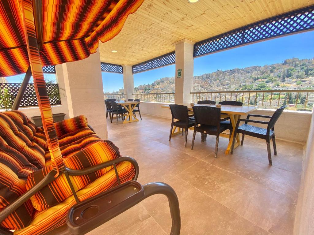 安曼Villa Mira GuestHouse 2 - Downtown Central Amman的带阳台的带桌椅的房间
