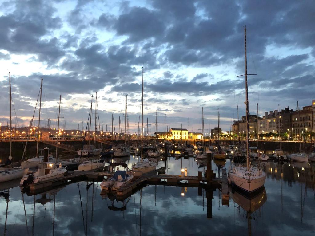 希洪Alojamientos Muelle de Gijón的一群船在晚上停靠在码头