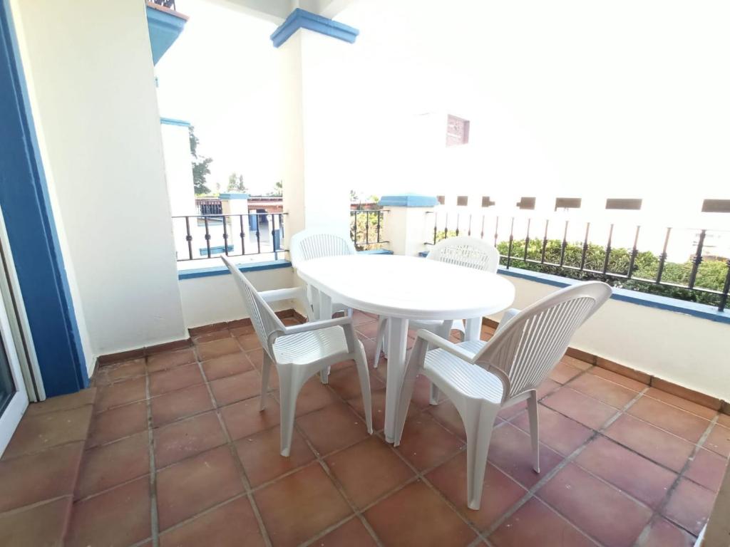 卡内拉岛Acogedor apartamento a 50 metros de la playa的阳台上配有白色的桌椅