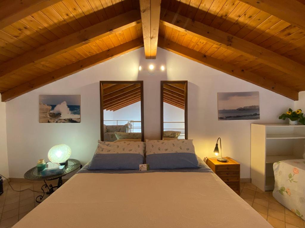 LizzanelloCeli Blu Appartamento的一间卧室设有一张大床和两个窗户。
