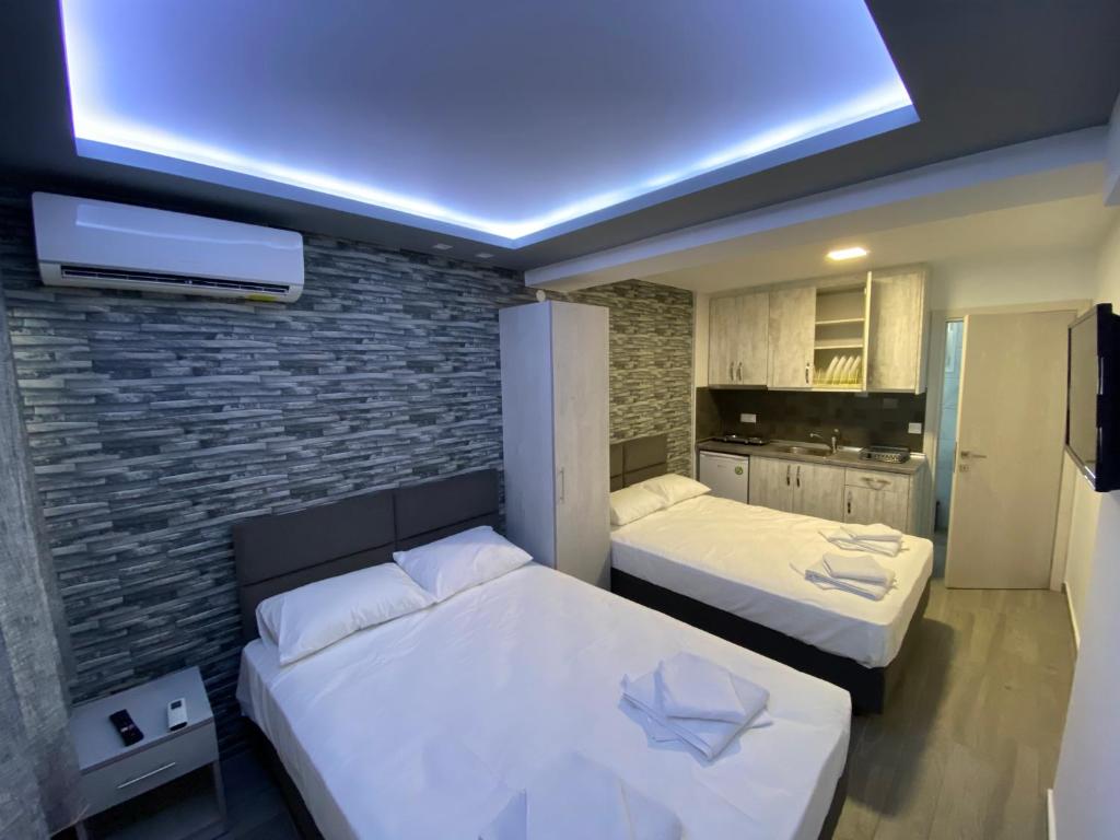 奥林匹亚基·阿克蒂Vila Savic的一间卧室设有两张床和砖墙