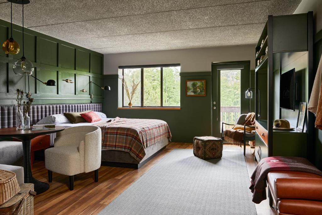 亨特Hunter Lodge, a Bluebird by Lark的一间卧室设有绿色的墙壁、一张床和一张书桌