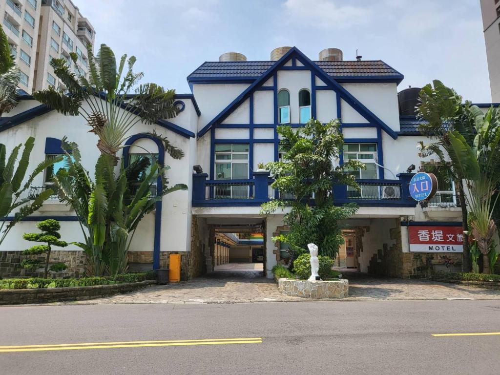 六龟Chateau Motel & Spa - Nanzi的一座带门廊的蓝色和白色大建筑