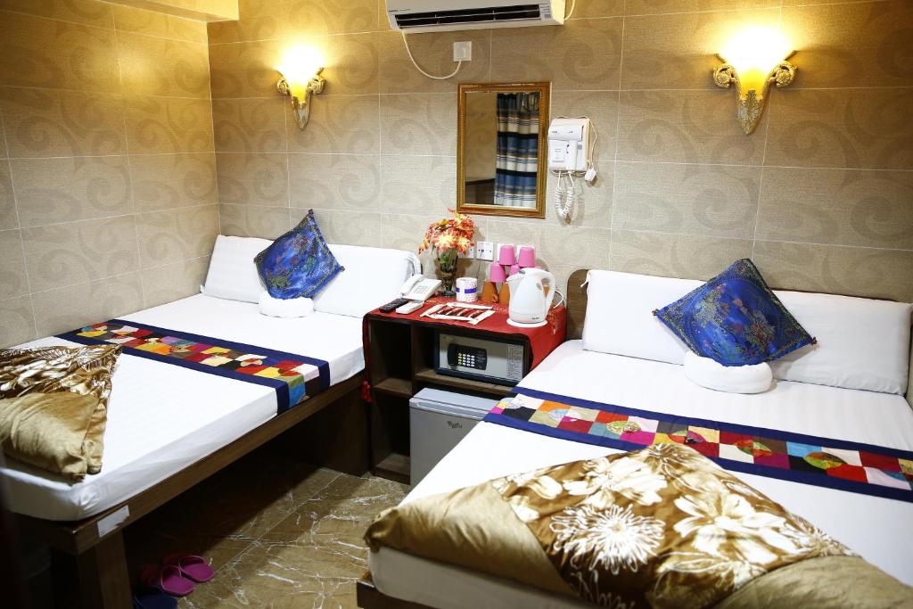 香港Sandhu Guest House的客房设有两张床和一张书桌