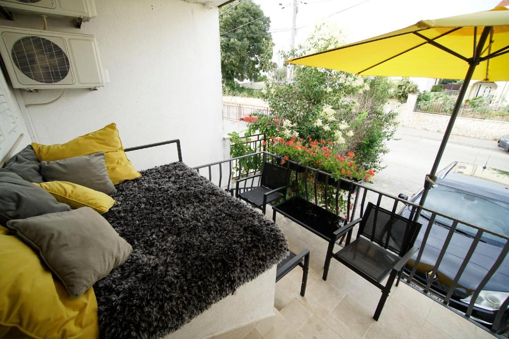 扎达尔A&N Zadar的阳台配有沙发和遮阳伞。