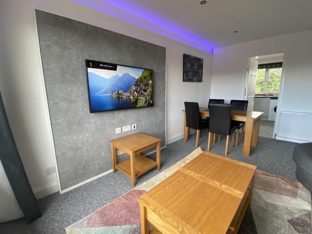 邓弗姆林Pure Apartments Fife - Dunfermline - Pitcorthie的客厅配有桌子和墙上的电视
