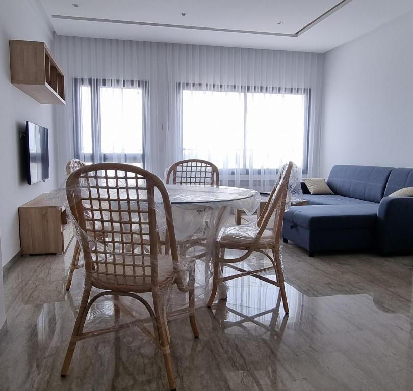 哈马马特Hammamet vue mer的客厅配有桌椅和沙发