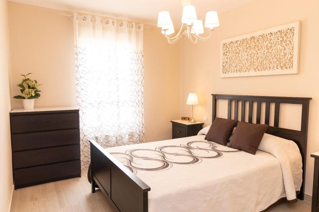 圣马丁德拉韦加La casa de San Martín. Parque Warner, Madrid的一间卧室配有一张带白色床罩的大床
