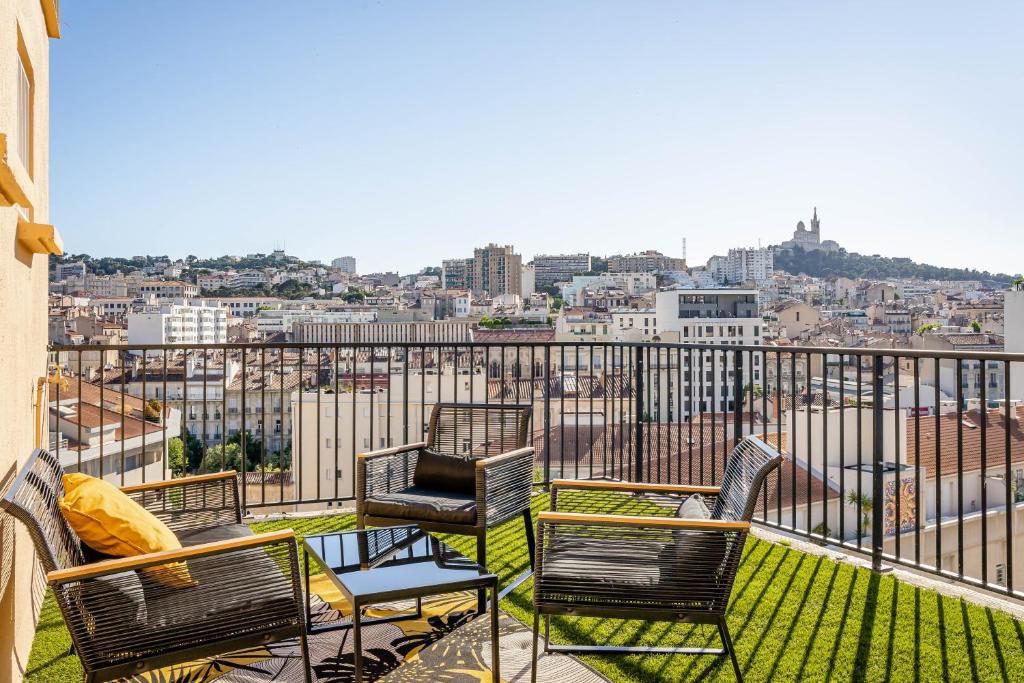 马赛Marseille: Superbe vue sur Notre-Dame de la Garde的市景阳台配有椅子