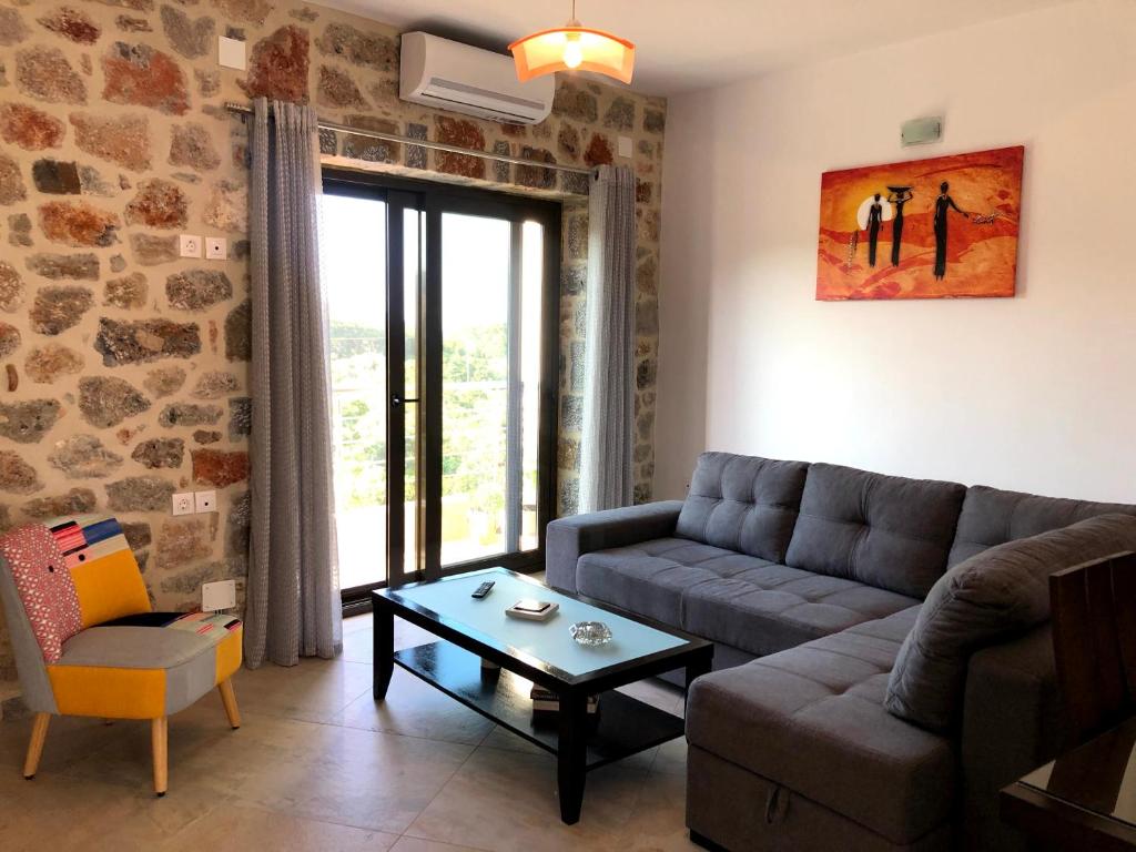 阿基欧斯尼古拉斯Oikia Stone House in seaside Kalo Chorio的客厅配有沙发和桌子
