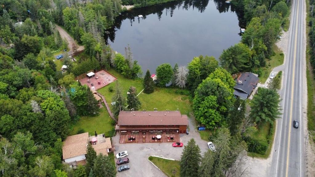 圣阿黛拉Hotel Le Petit Lac Sainte-Adèle的享有房子和湖泊的空中景致