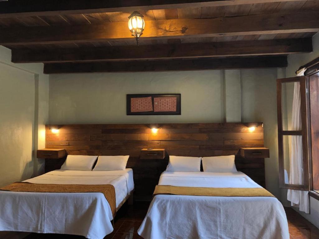 圣克里斯托瓦尔-德拉斯卡萨斯Arte Sano Hotel San Cristobal的一间客房内配有两张床的房间