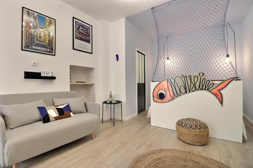 马赛La Sardine du Panier®的客厅配有沙发和墙上的鱼