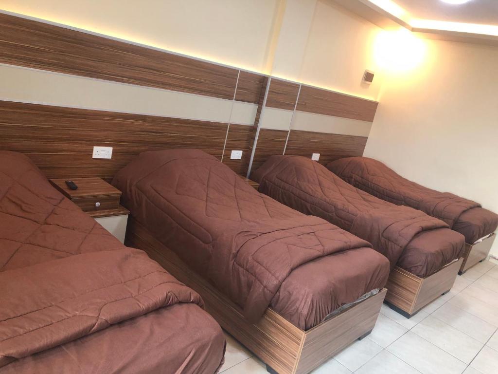 亚喀巴Al Deyafa Hotel的三个床在一间房间里排成一排