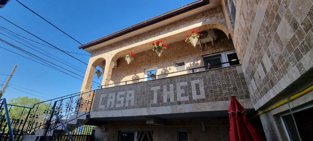 曼加利亚Vila Theo的一座建筑,阳台上装有红色的鲜花