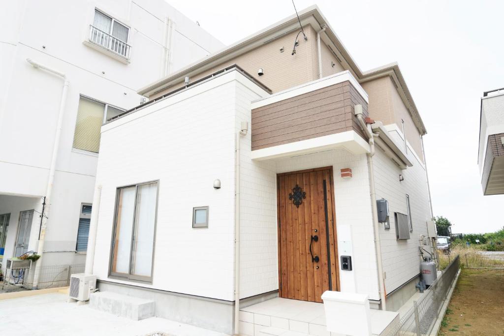 Agarii名護ビーチハウス的白色的房子,设有木门
