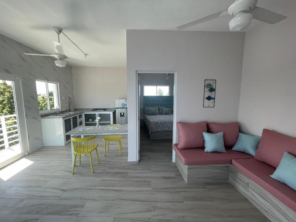 里奥圣胡安Apartamentos La Torre的一间带红色沙发的客厅和一间厨房