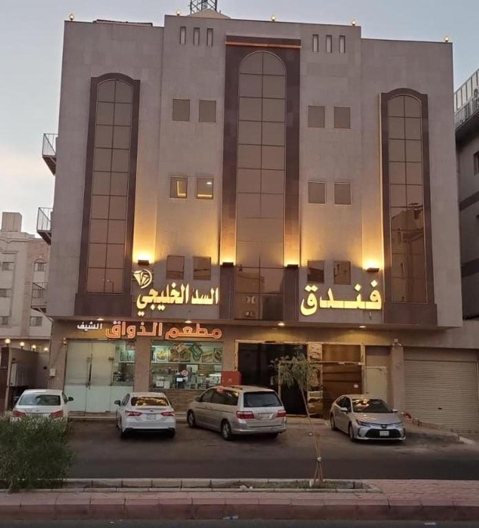 Sīdī Ḩamzahفندق السد الخليجى的前面有汽车停放的建筑