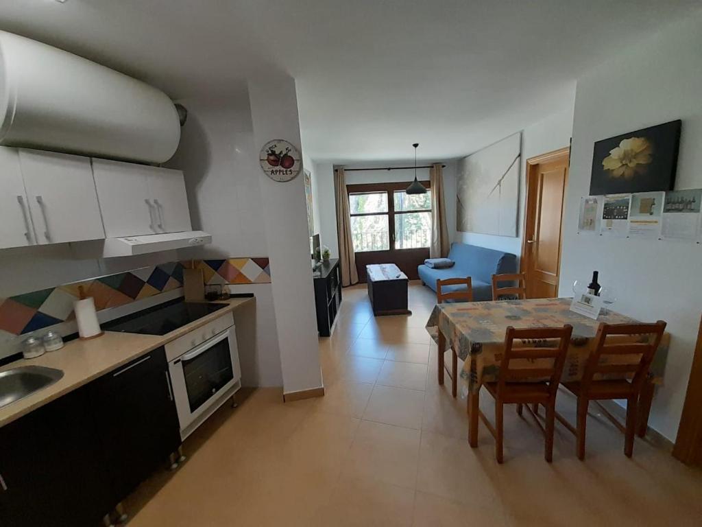 阿尔克萨尔La Cocineta - Redolada的厨房以及带桌椅的起居室。