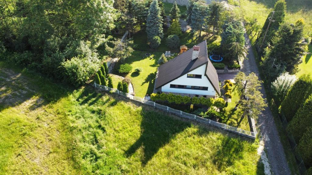 SułkowiceRetro Domek - Domek z ogrodem w górach的绿色田野上白色房子的空中景色
