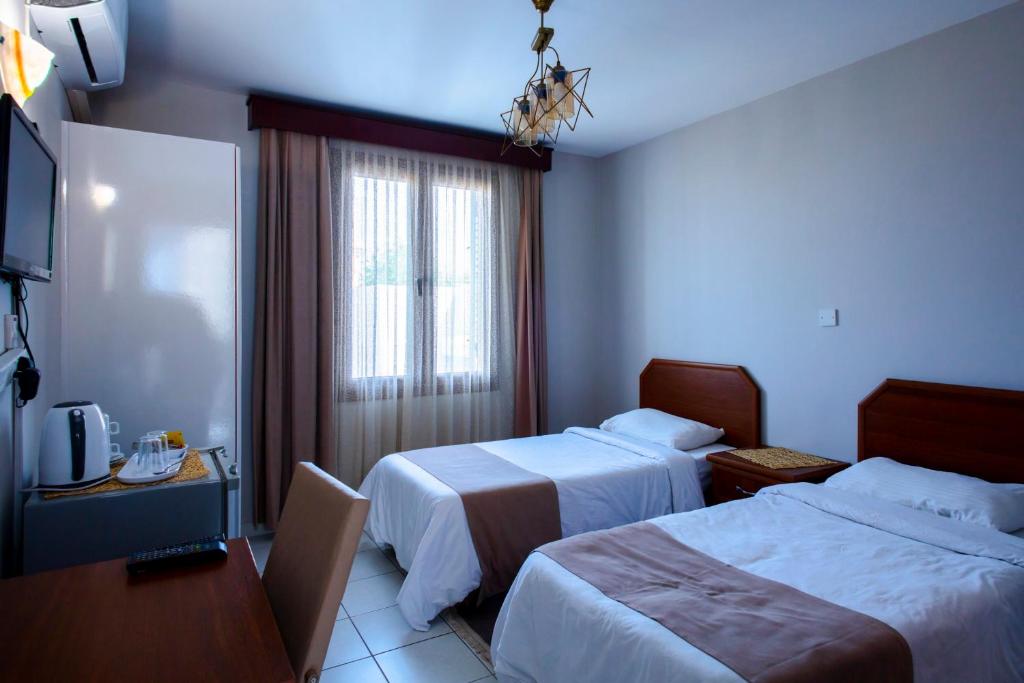 凯里尼亚Homelike Guest house的酒店客房设有两张床和电视。