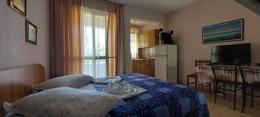 都拉斯Villa Madani的一间卧室配有一张带蓝色棉被的床