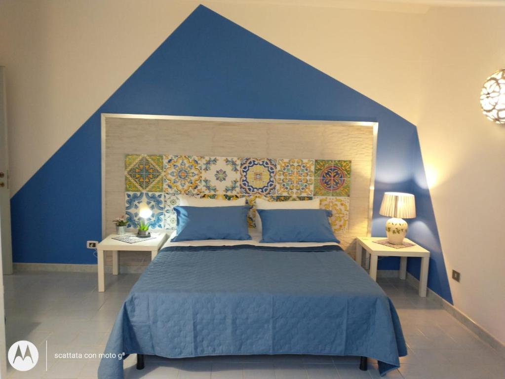 庞特卡格纳诺IDA S Apartament的蓝色卧室设有一张带蓝色墙壁的大床