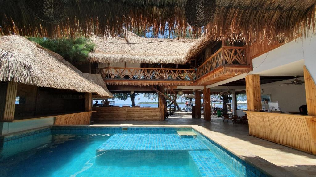 吉利特拉旺安桑巴海滨景观别墅酒店的一座带大楼的度假村前的游泳池
