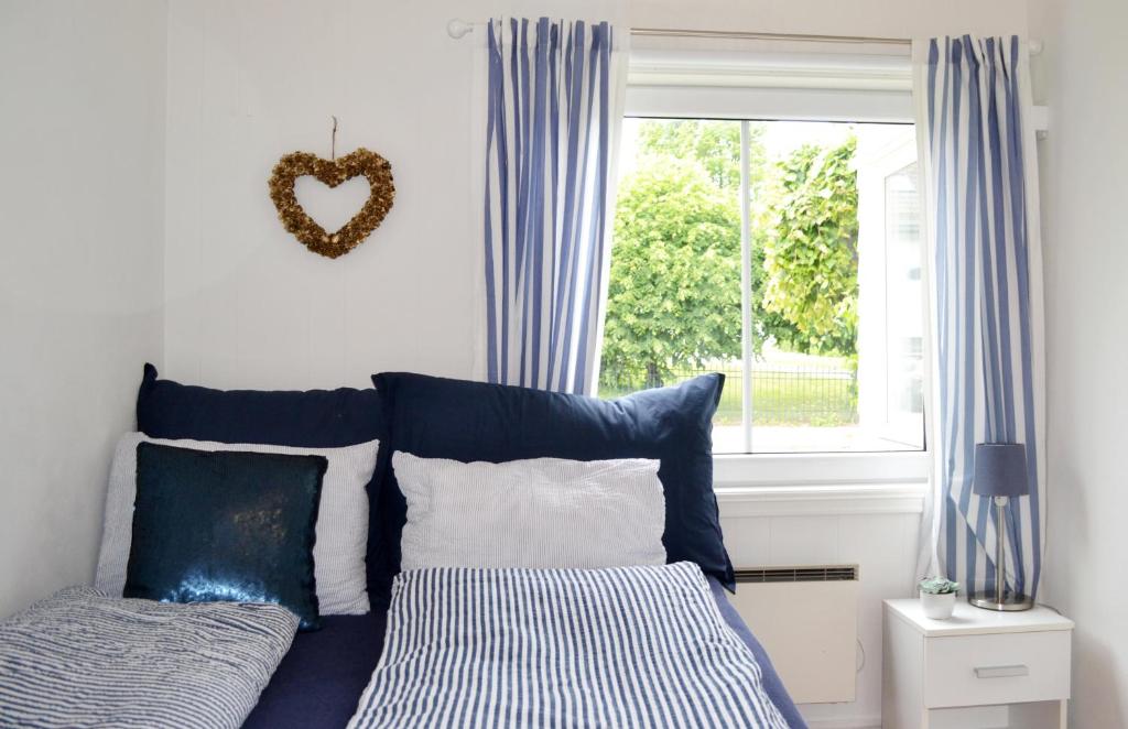 滕斯贝格Endless Summer的一张带蓝色和白色枕头的床和窗户