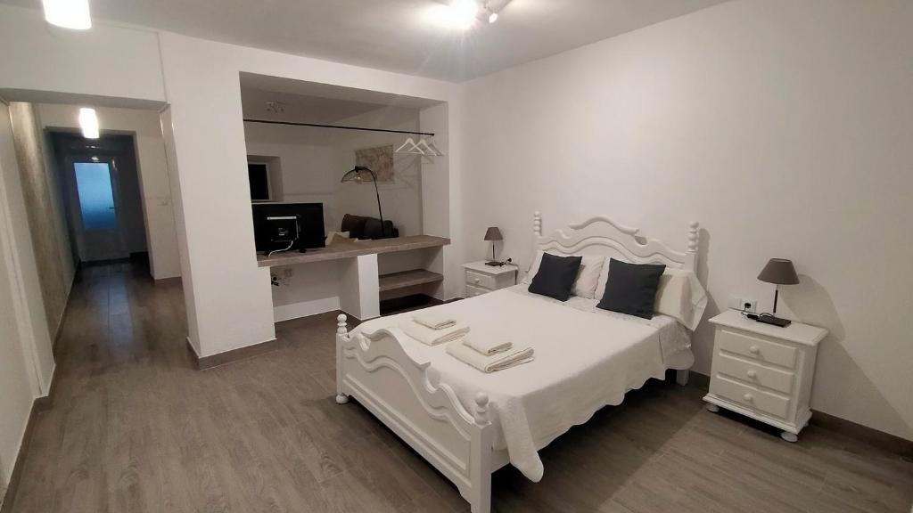 梅里达Castella Aquae II Amplio loft para dos的白色卧室配有白色的床和书桌