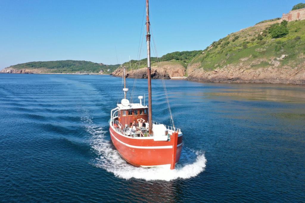 海斯勒Unique Boat Accomodation - Bornholm的水中一艘红白的船