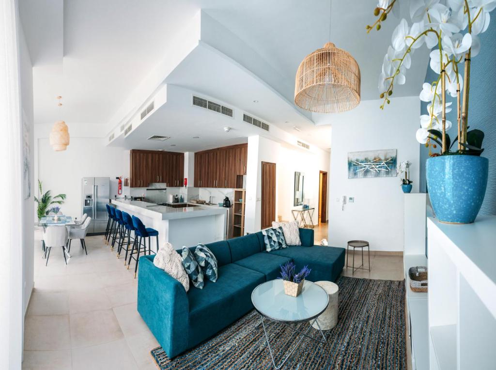 拉斯阿尔卡麦Family vacation villa with private pool and access to beach的一间带蓝色沙发的客厅和一间厨房