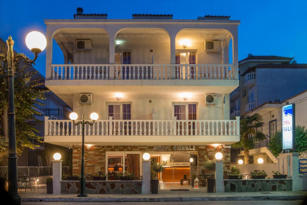 帕拉利亚卡泰里尼斯考拉里酒店的街道上一座大型白色建筑,设有阳台