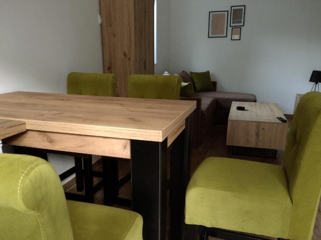 索科矿泉村Smestaj Stanisavljevic的一间会议室,配有木桌和绿色椅子