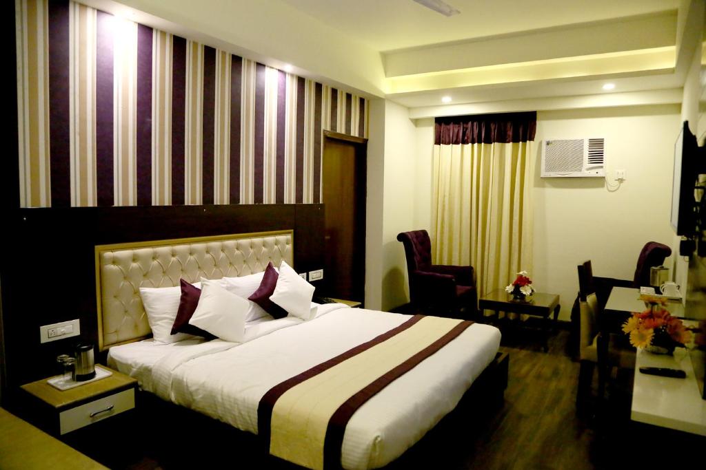 齐拉克普尔Hotel S C Residency的酒店客房带一张大床和椅子